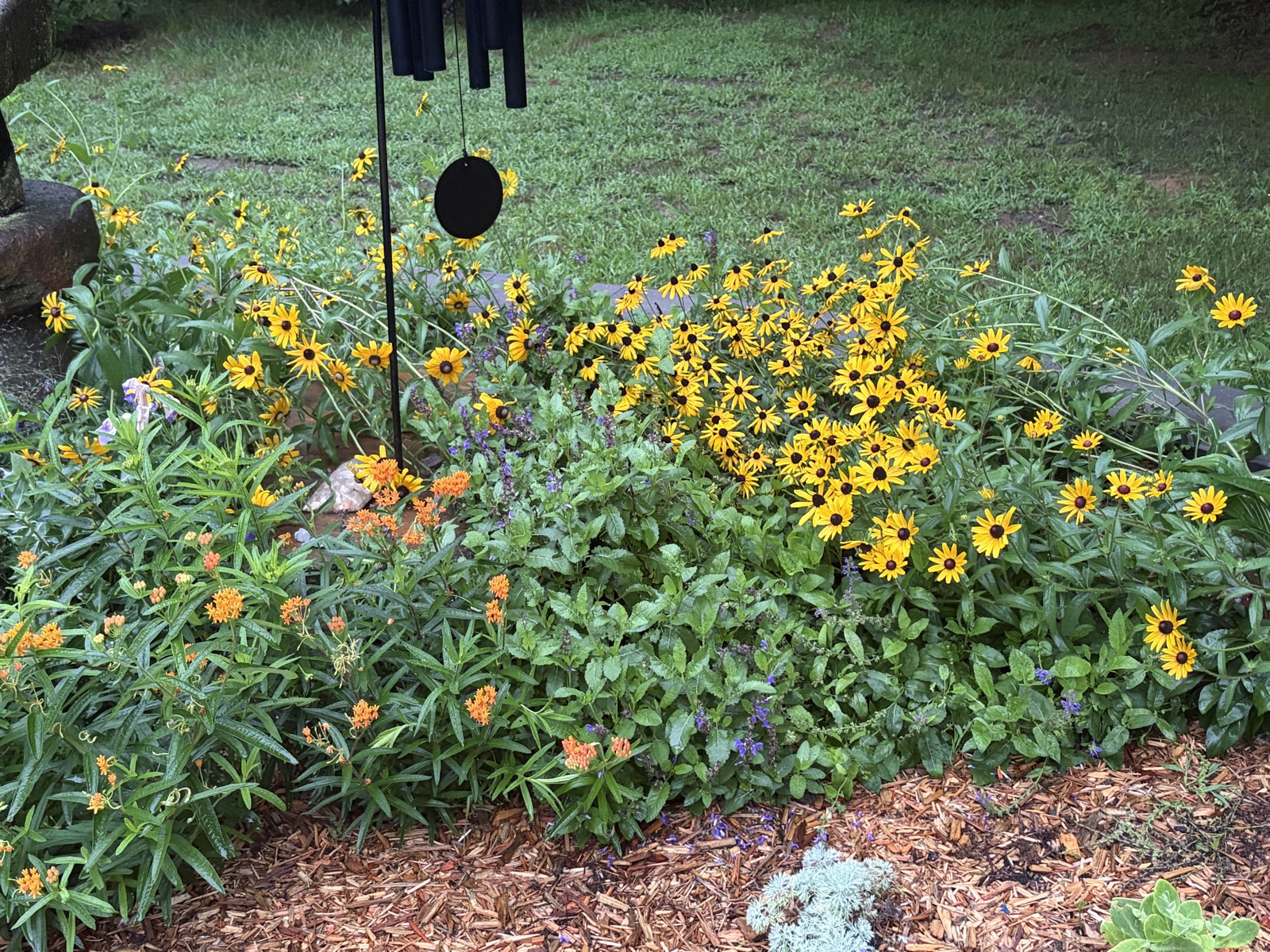 Wind chime over a bed of black-eyed Susans and butterfly weed